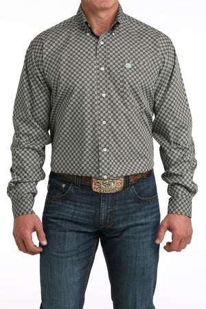 Man wearing a patterned shirt and jeans on a white background