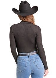 A woman wearing a black long-sleeve mock neck top. 