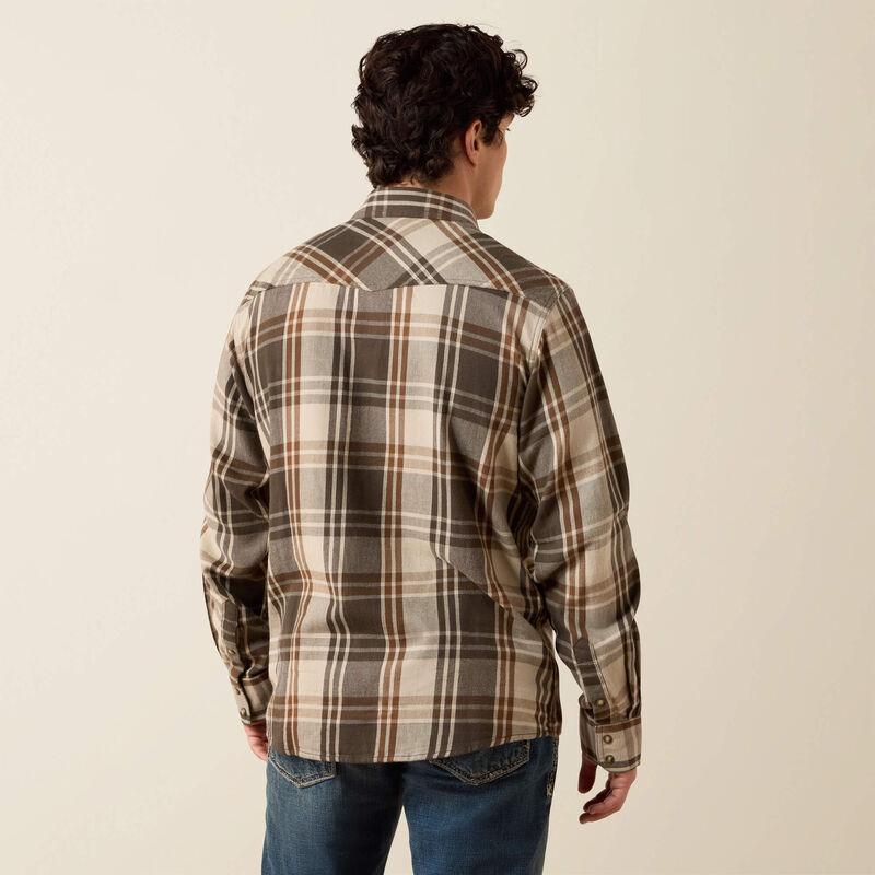 A man wearing a green and beige plaid button-down shirt 