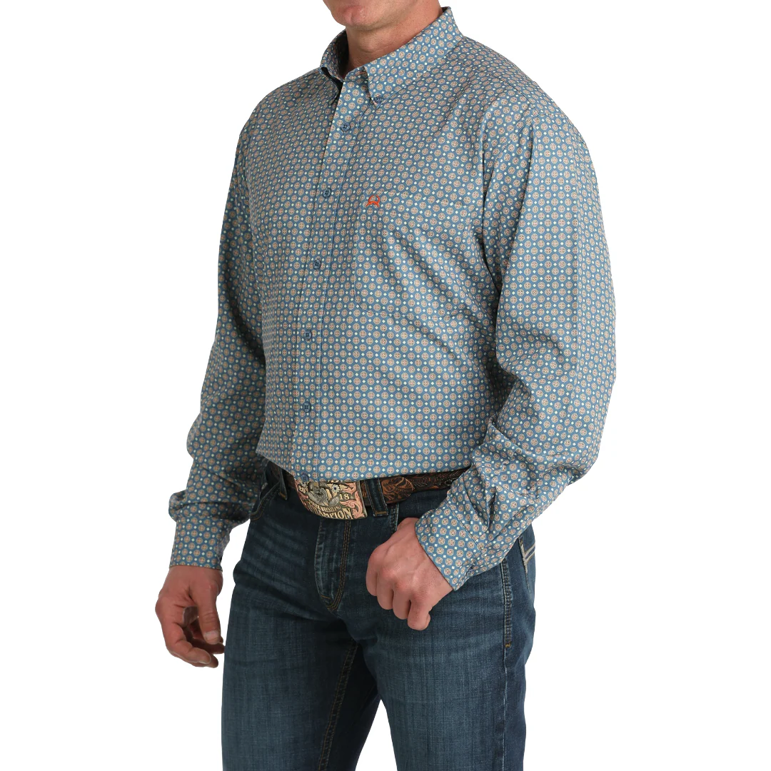 Man wearing a patterned shirt and jeans on a white background