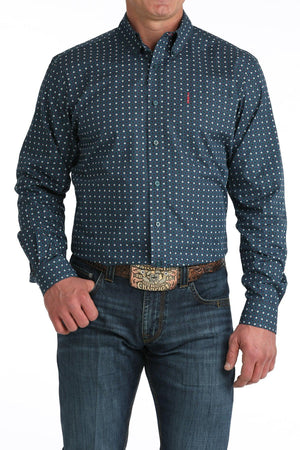Man wearing a blue patterned shirt and jeans on a white background
