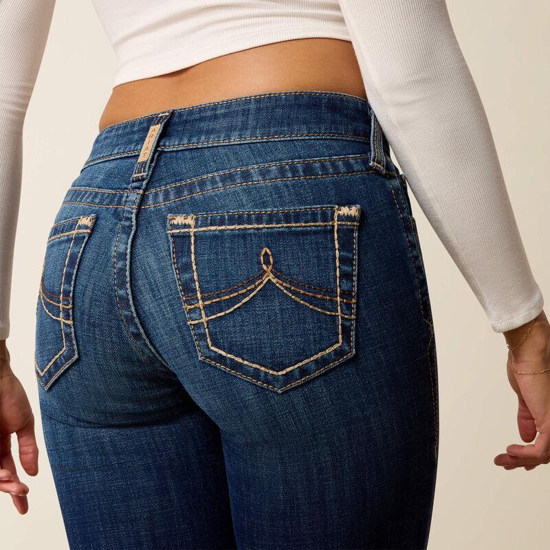 Person wearing blue jeans with a plain background