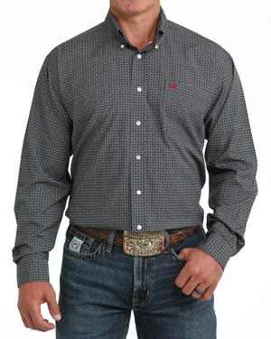 A man wearing a blue and burgundy micro-patterned western long-sleeve button-down shirt with a small red embroidered logo on the chest 