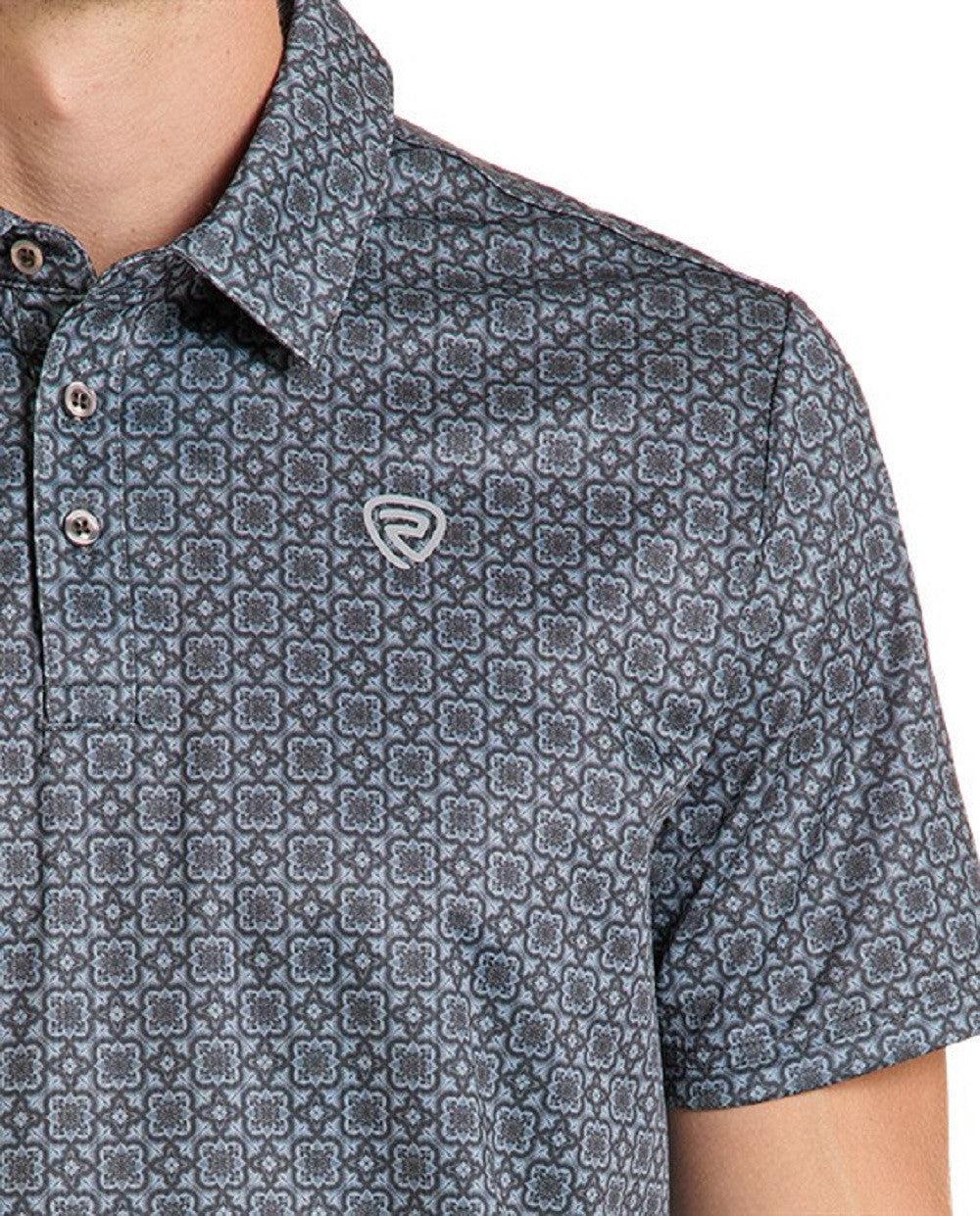 Close-up of a man wearing a short-sleeve polo shirt with a repeating geometric pattern
