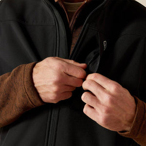 Person wearing a black vest with a brand logo. 