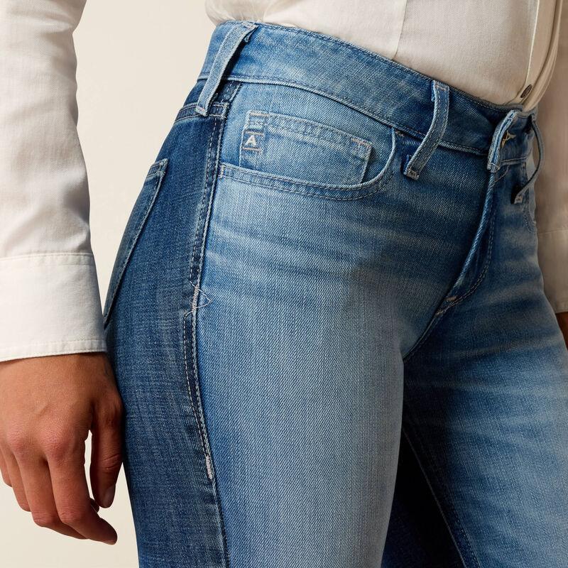 Close-up of blue jeans worn by a person with a neutral background