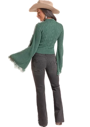 A woman shown from the back wearing a sage green knit sweater with long fringed bell sleeves. 
