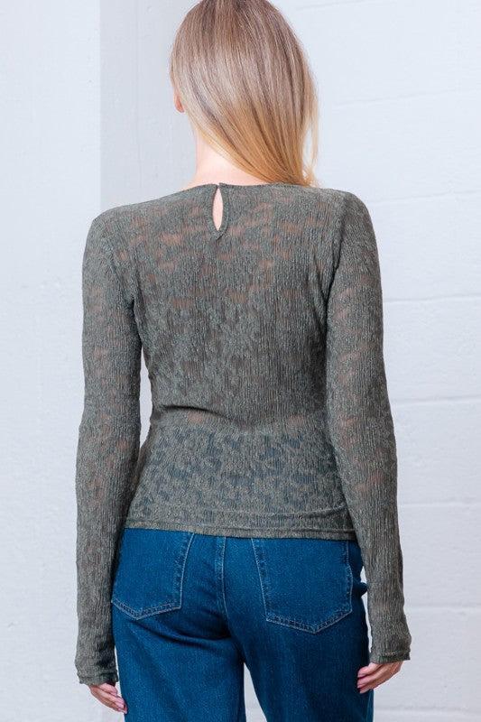 Woman wearing a green patterned long-sleeve top 