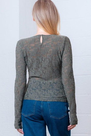 Woman wearing a green patterned long-sleeve top 