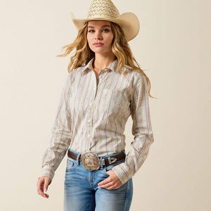 Woman wearing a striped shirt, jeans, and a cowboy hat on a beige background