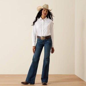 Woman wearing a white shirt, blue jeans, and a cowboy hat on a plain background