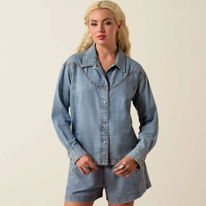 Woman wearing a denim shirt against a beige background