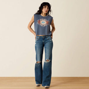 A model wearing blue distressed flare jeans with ripped knees