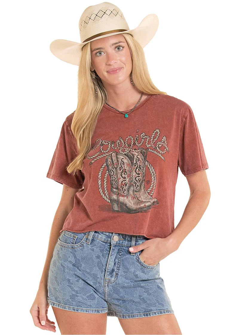 Woman wearing a red graphic t-shirt with a cowboy boot design, denim shorts, and a beige cowboy hat on a white background.