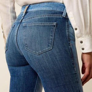 Close-up of blue jeans with a beige background