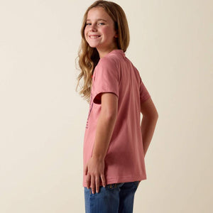 Person wearing a pink t-shirt with a purple graphic design on a beige background