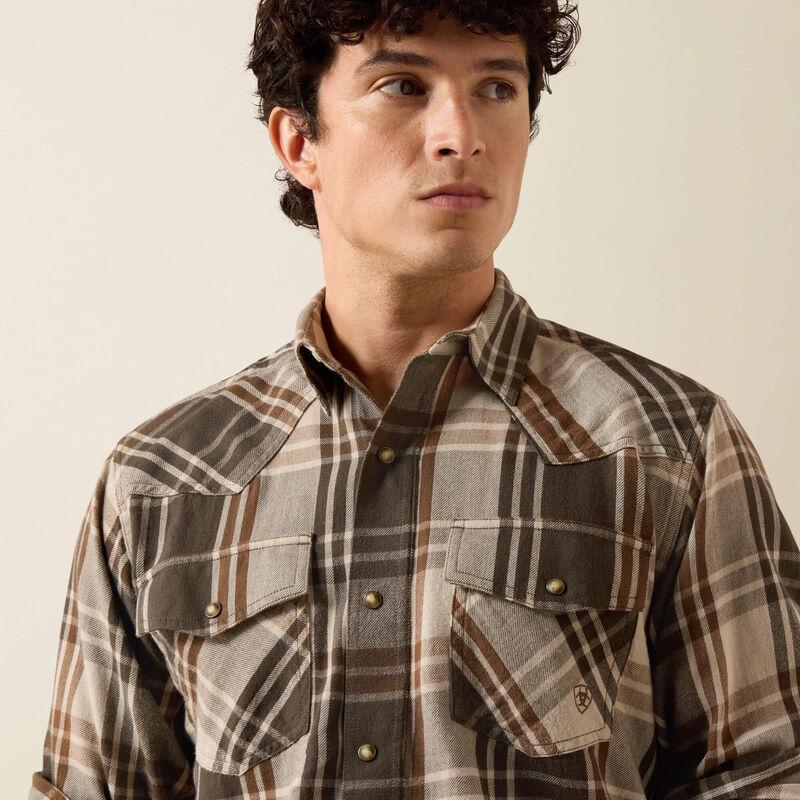 A man wearing a green and beige plaid button-down shirt 
