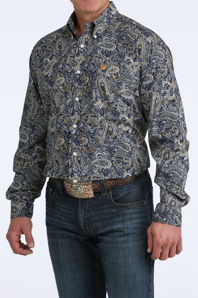 Man wearing a patterned shirt and jeans on a white background