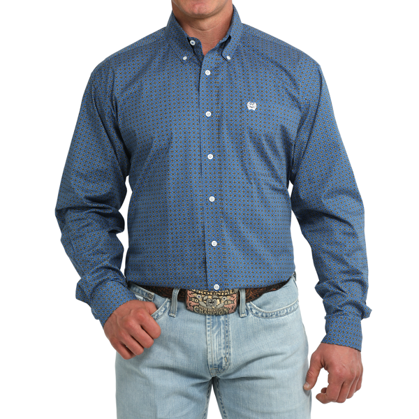 A man wearing a blue long-sleeve button-down shirt with a small geometric pattern, paired with light-wash jeans and a western belt, shown from the chin down on a white background.