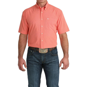 Man wearing a red short-sleeve shirt and blue jeans on a white background
