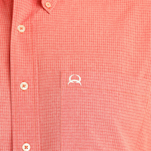 Man wearing a red short-sleeve shirt and blue jeans on a white background
