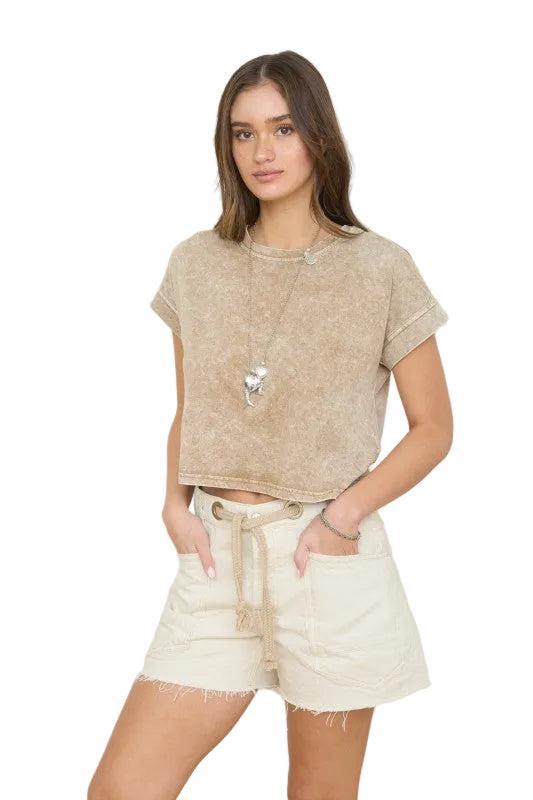 Woman wearing a brown short sleeve top.