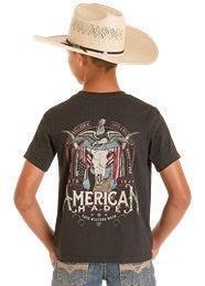 Child wearing a dark gray t-shirt with a graphic design and 'American' text, standing against a white background.