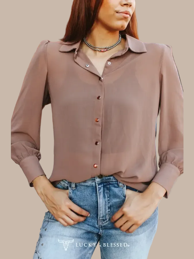 A woman wearing a mocha long-sleeve button-up blouse. 