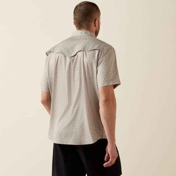 Man wearing a short-sleeve shirt with a subtle pattern on a beige background