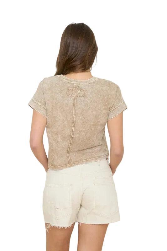 Woman wearing a brown short sleeve top.