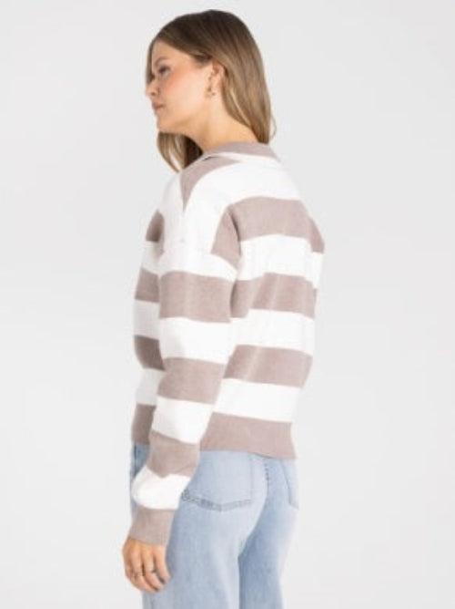 A woman wearing a cropped long-sleeve knit sweater with horizontal taupe and white stripes