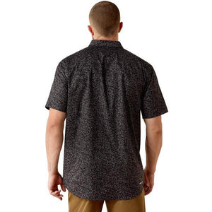 Man wearing a black patterned short-sleeve shirt 