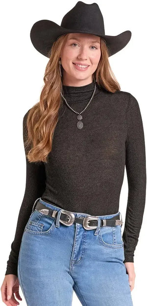 A woman wearing a black long-sleeve mock neck top. 