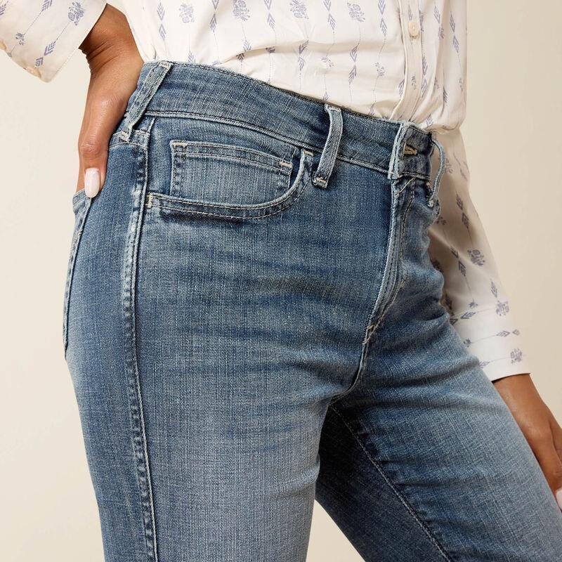 Close-up of blue jeans worn by a person with a neutral background