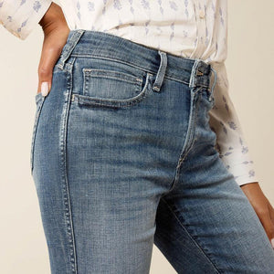 Close-up of blue jeans worn by a person with a neutral background
