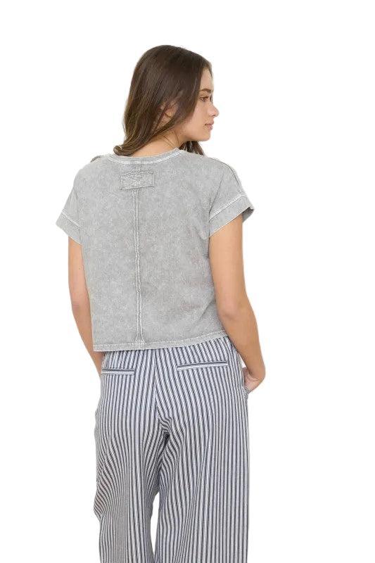 Woman wearing a brown short sleeve top.