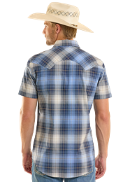 Man wearing a blue plaid shirt and cowboy hat outdoors