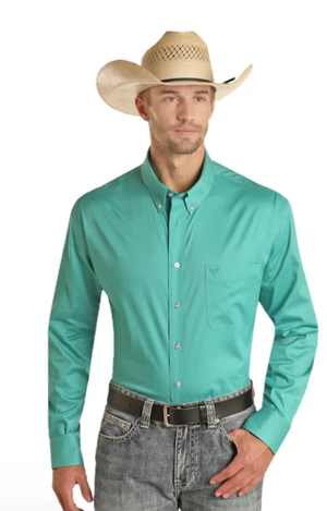Man wearing a turquoise shirt, gray jeans, and a straw cowboy hat on a white background
