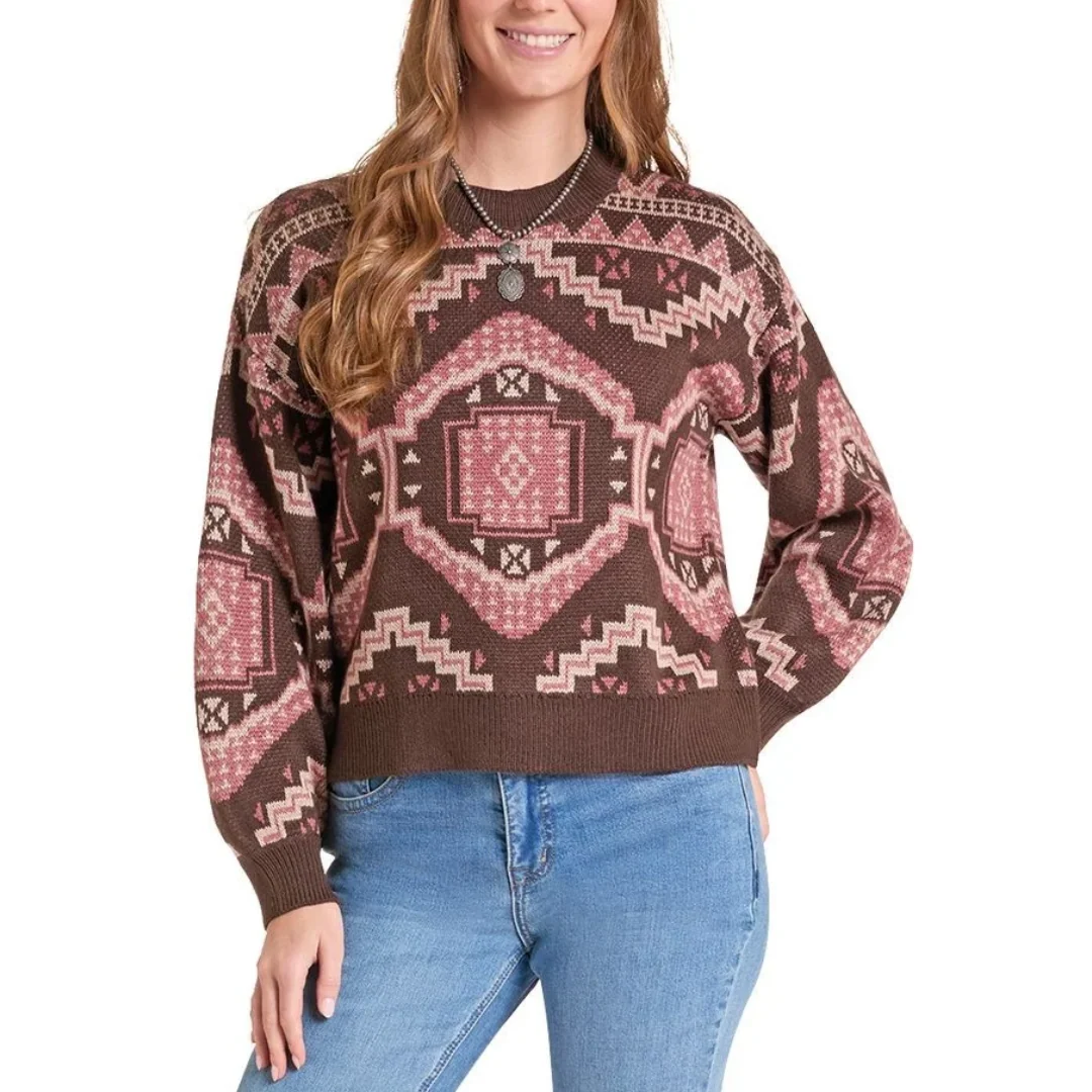 A woman wearing a brown knit sweater with a pink and beige geometric southwestern pattern