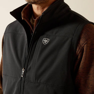 Black vest with a brand logo worn by a person, on a neutral background
