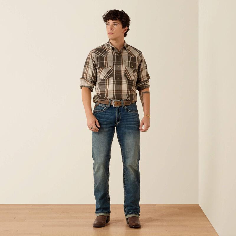 A man wearing a green and beige plaid button-down shirt 