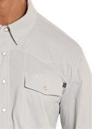 Close-up of a person wearing a light gray button-up shirt with a pocket detail.