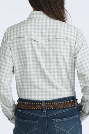 Person wearing a checkered shirt and jeans with a decorative belt on a white background