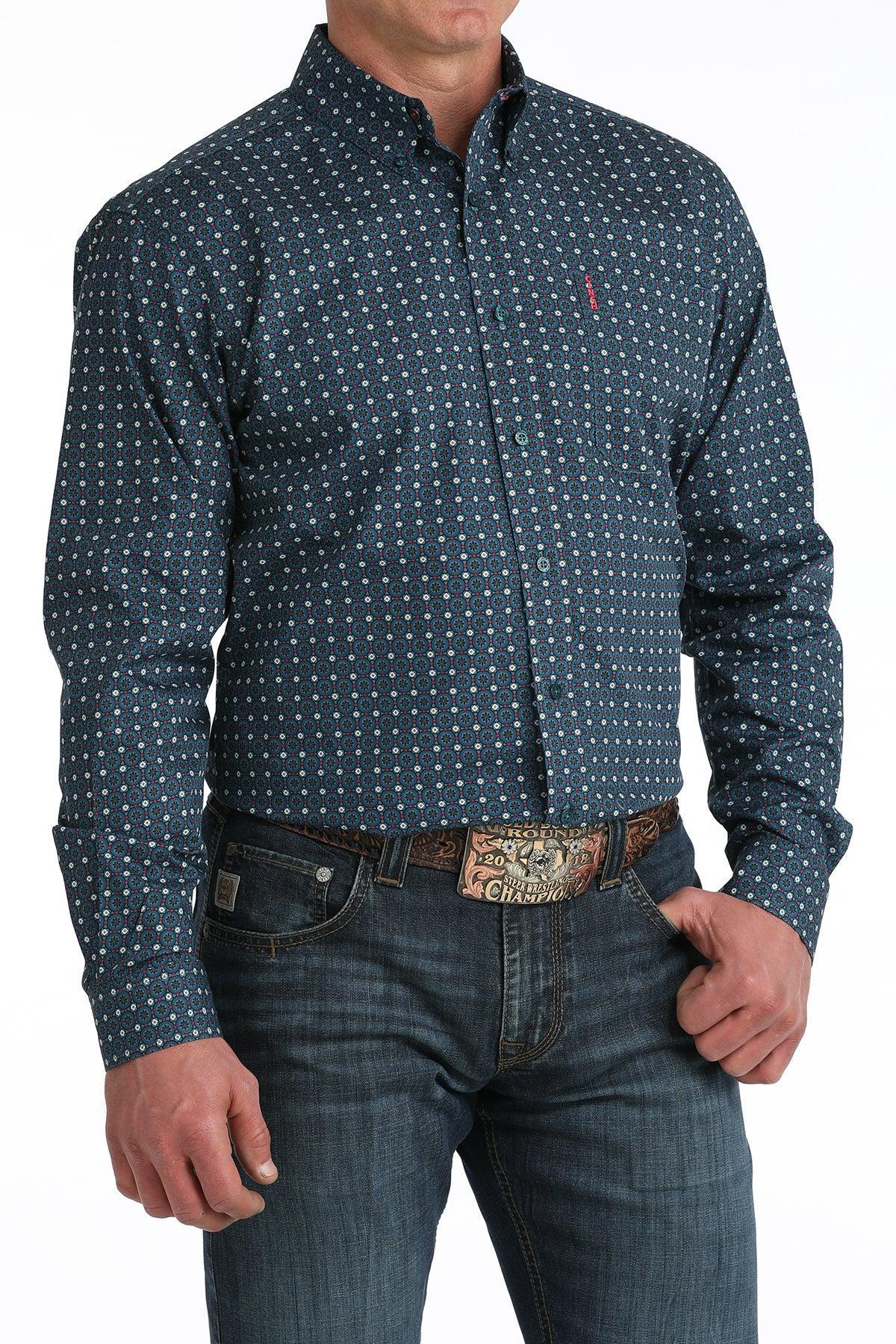 Man wearing a blue patterned shirt and jeans with a belt buckle.