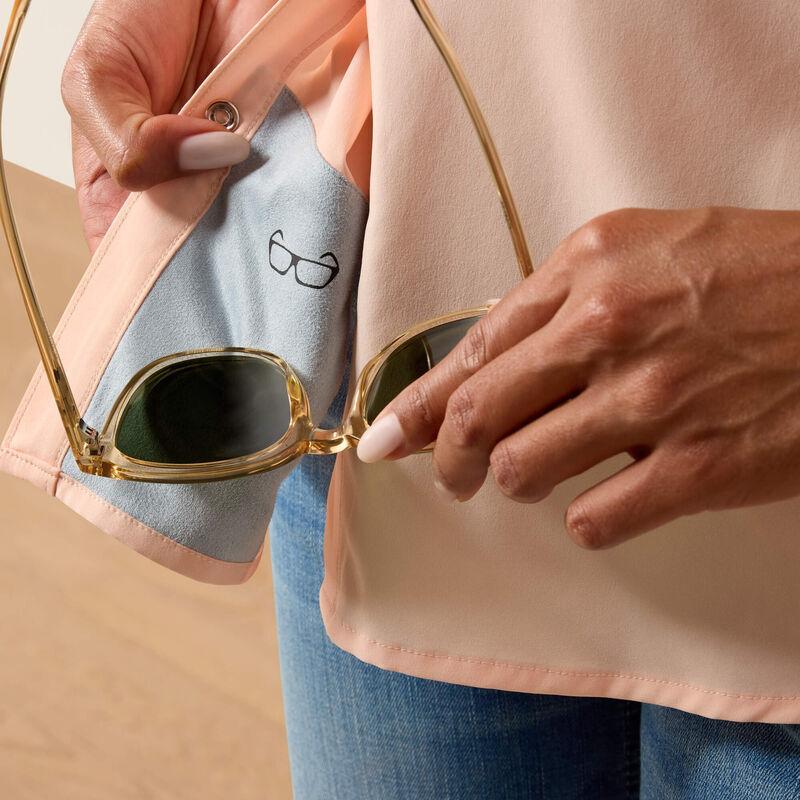 Woman wearing a light peach shirt and blue jeans with a beige hat on a beige background