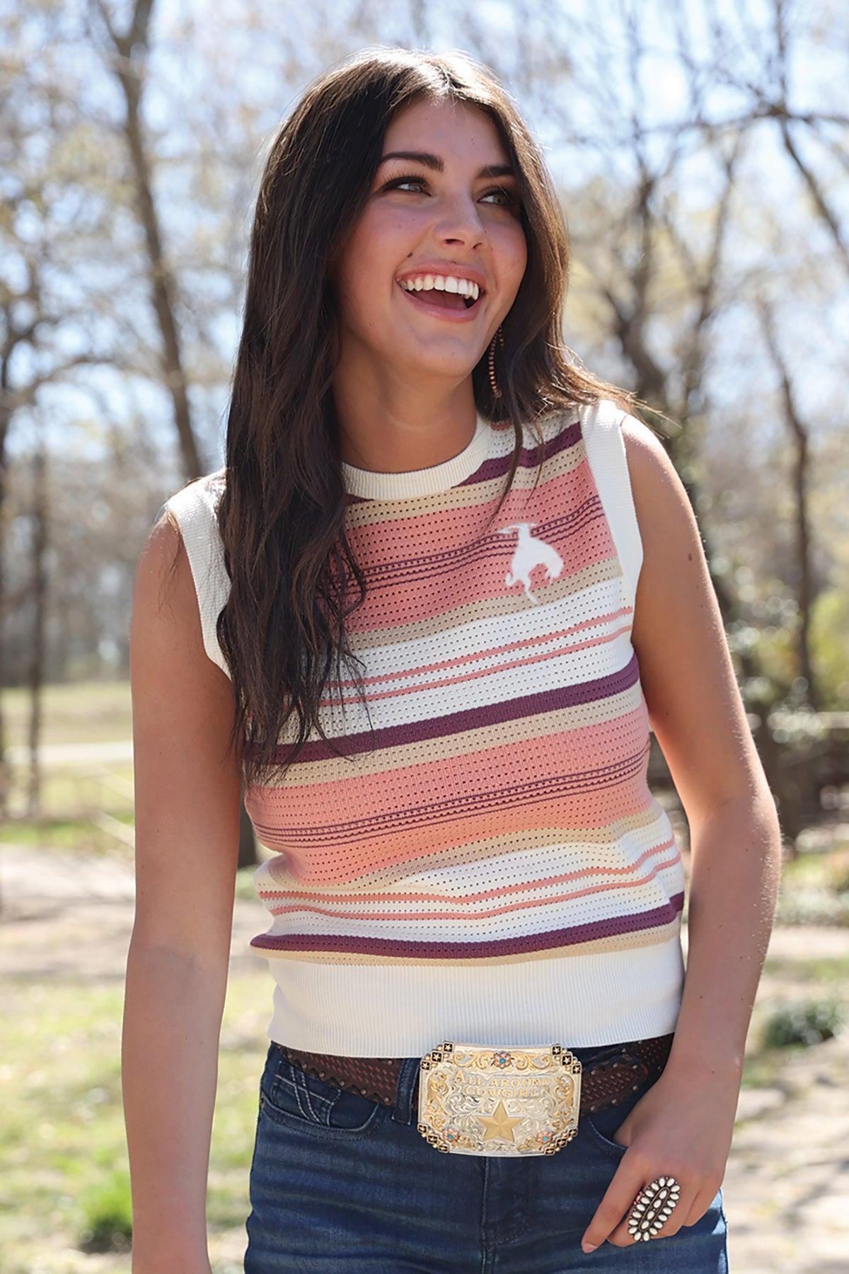 Woman wearing a striped sleeveless top with a belt buckle in an outdoor setting