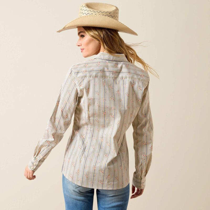Woman wearing a patterned shirt and cowboy hat on a beige background
