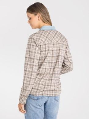 A woman shown from the back wearing a beige and brown plaid button-up shirt with a light blue collar, paired with light blue jeans, against a plain white background.