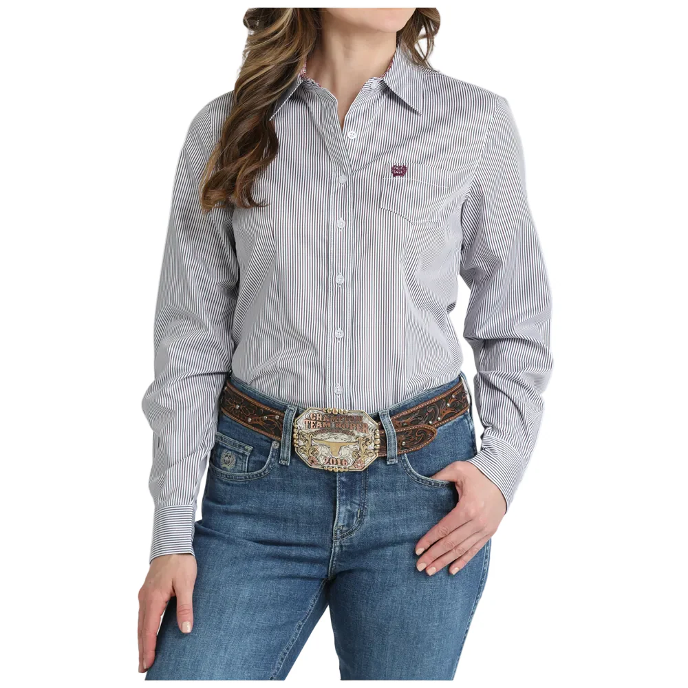 Person wearing a gray striped shirt and blue jeans with a decorative belt.