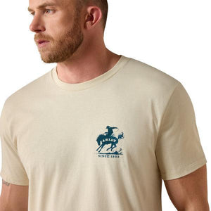 Man wearing a beige t-shirt with a blue logo on a white background